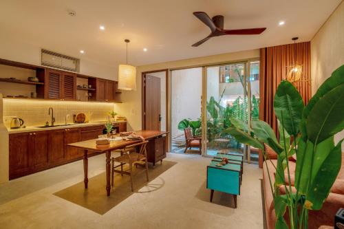 a kitchen with a table and a dining room at Camfusion Hoi An in Hoi An