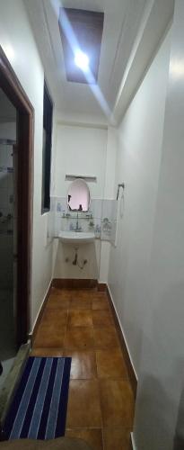 a bathroom with a sink and a mirror on the ceiling at Aangan Homestay in Pātan