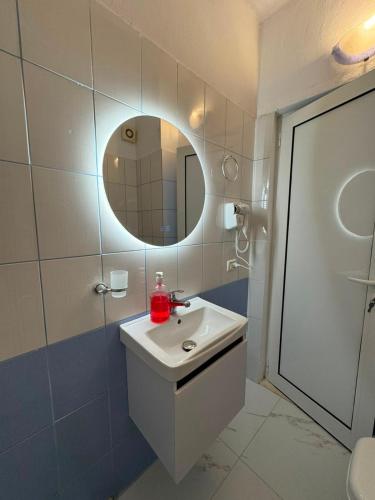 a bathroom with a sink and a mirror at Lushnja Central Elegance in Lushnjë