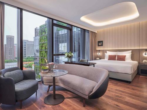 a hotel room with a bed and a large window at Pullman Singapore Hill Street in Singapore