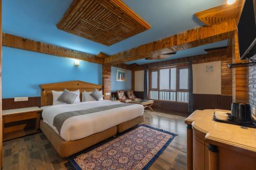 a bedroom with a bed and a desk and a television at Splendid Retreat Hotels Kufri in Kūfrī