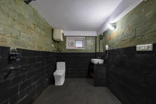 a black bathroom with a toilet and a sink at Splendid Retreat Hotels Kufri in Kūfrī