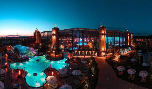 a large building with a swimming pool at night at Le Patio - à 20 minutes d'Europa-Park in Rhinau