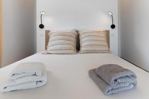 a white bed with two towels on it at Casa Alena in Cervione