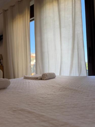 ein Schlafzimmer mit einem Bett, auf dem zwei Handtücher liegen in der Unterkunft Casa NiMa in Metókhion Apisianá