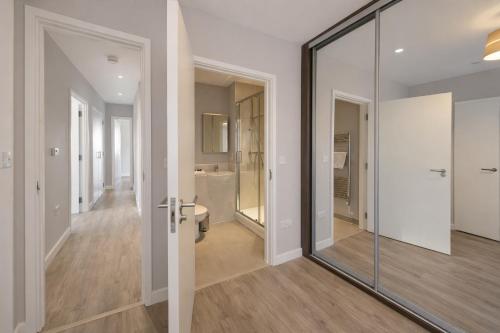 a hallway with a glass door and a bathroom at Roomspace Serviced Apartments - Vertex House in Croydon