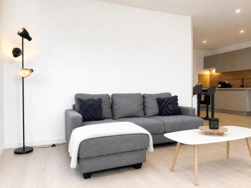 a living room with a gray couch and a table at L'AUTHENTIQUE - Moderne - Central in Mont-de-Marsan