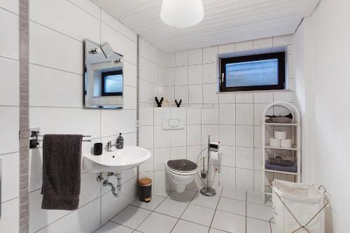 a white bathroom with a sink and a toilet at Schwarzwaldglück in St. Blasien