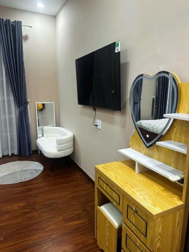 a bathroom with a mirror and a tv on the wall at Phố Homestay TĐT in Ấp Tân An (1)