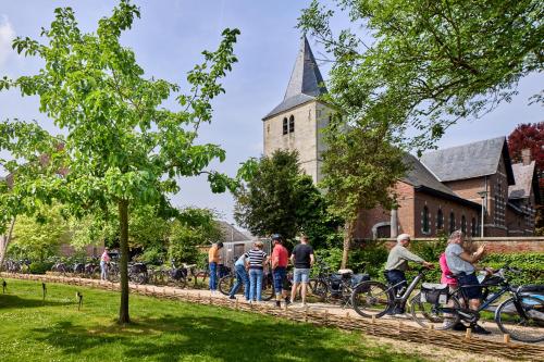 Eine Gruppe von Menschen auf Fahrrädern vor einer Kirche in der Unterkunft De Pastorie in Borgloon