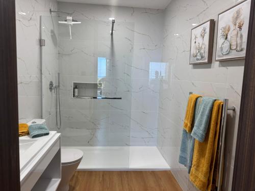a bathroom with a shower and a toilet and a sink at RR Suites in São Mateus