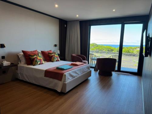 a bedroom with a bed and a view of the ocean at RR Suites in São Mateus