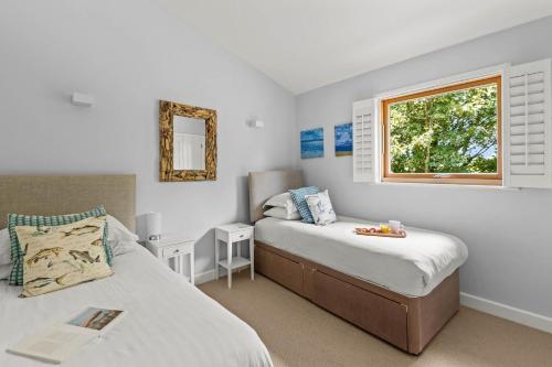 a bedroom with two beds and a window at House 38 in Looe