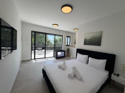 a bedroom with a white bed with two pillows on it at וילה יובל in Yuval