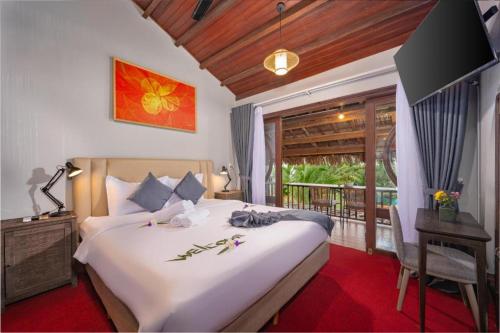 a bedroom with a large bed and a balcony at Hoianbang Beach Front Villa and Restaurant in An Bàn (2)