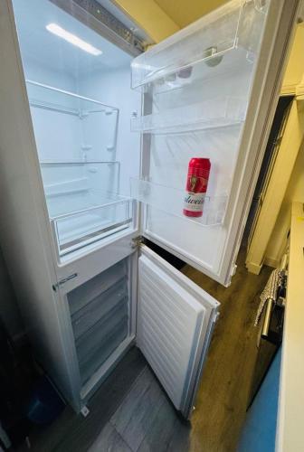 an empty refrigerator with its door open in a kitchen at Romford 4-Bed Home Sleeps 7 with Garden & Parking in Romford