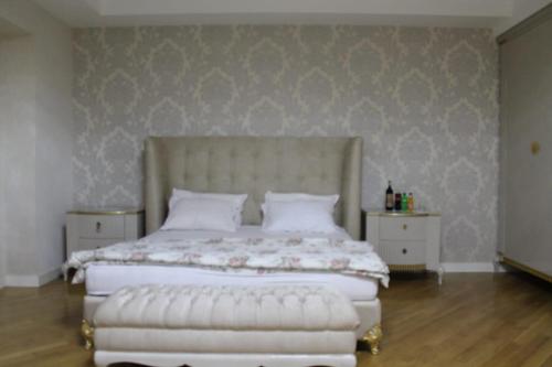 a bedroom with a large white bed with a white tufted headboard at HILTON Residence of LUXURY 5 STARS apartment F1 in Baku