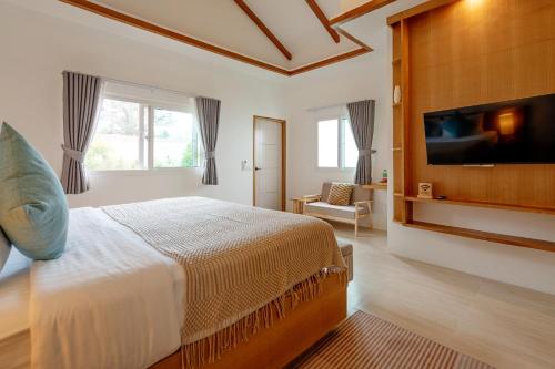 ein Schlafzimmer mit Bett und Flachbildfernseher in der Unterkunft Lerwin House in Bophut 