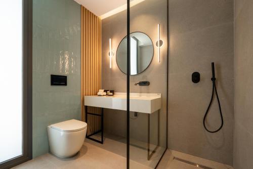 a bathroom with a toilet and a sink and a shower at Poseidon by Deserve in Paphos