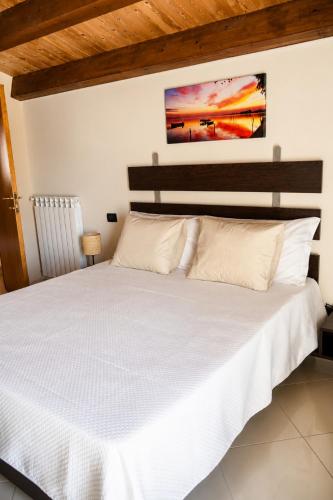 a bedroom with a large bed with white sheets at Istmo Room and Breakfast in Lesina
