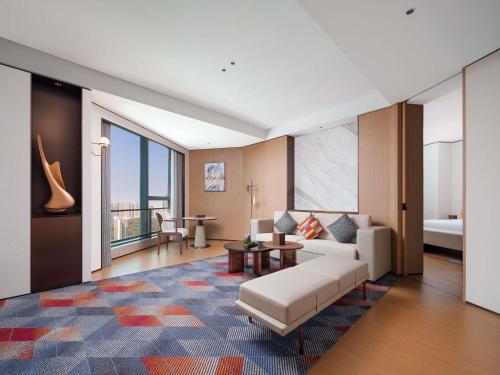 a living room with a couch and a table at Pullman Chongqing Xiyue in Chongqing