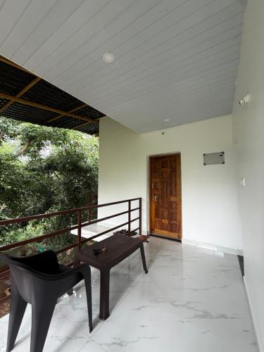 a room with a table and a chair on a balcony at Tangerine House in Canacona