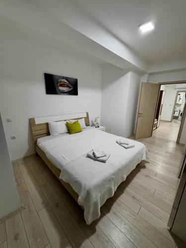 a bedroom with a large white bed with yellow pillows at Neptun Apartments in Gevgelija