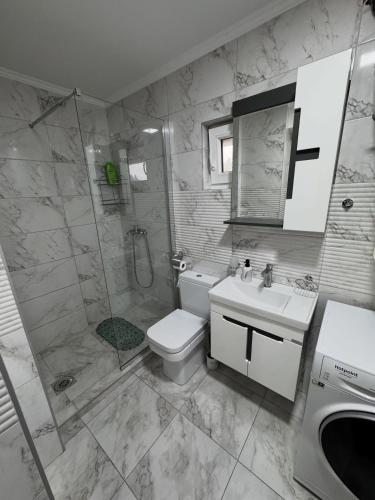 a bathroom with a shower and a toilet and a sink at Neptun Apartments in Gevgelija