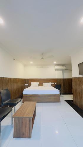 a bedroom with a bed and a table and chairs at Tirupati Stays in Tirupati
