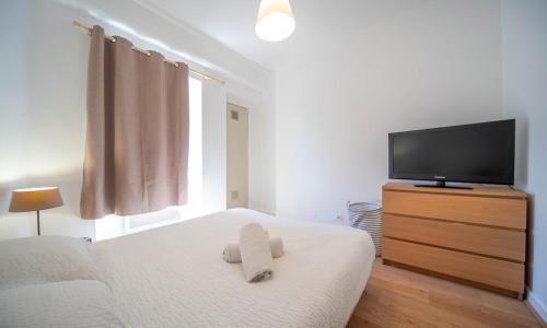 a bedroom with a bed and a flat screen tv at Studio cosy - proche cathédrale in Chalon-sur-Saône