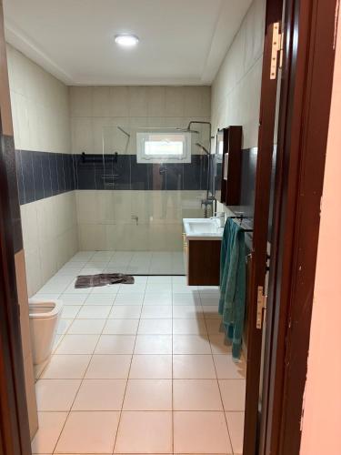 a bathroom with a shower and a toilet and a sink at Campbell Residence Bouaké in Bouaké