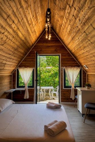 a bedroom with a large bed in a wooden house at Koman Twin Cabins in Gushtë