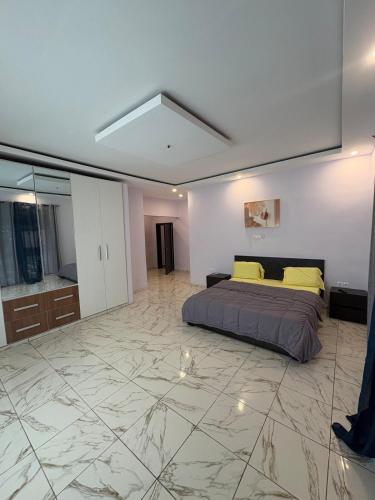 a bedroom with a bed and a marble floor at Campbell Residence Bouaké in Bouaké