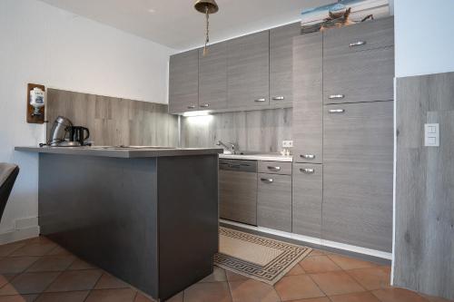 a kitchen with wooden cabinets and a counter top at Haus Biene am Meer in Norden