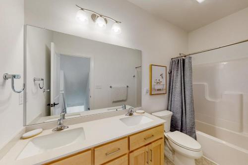 a bathroom with a sink and a toilet and a mirror at Sapphire Sol in Ocean City
