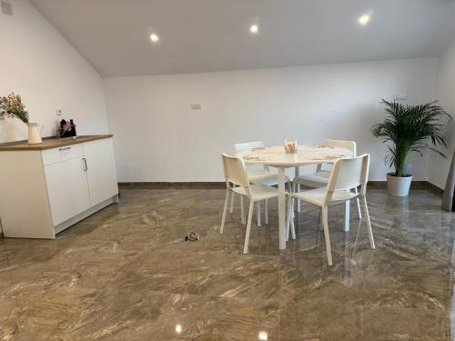 a white table and chairs in an empty room at SAN Apartments Near Belgrade Airport in Surčin