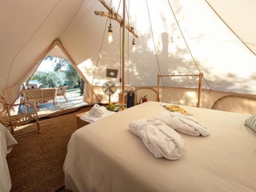 a room with two towels on a bed in a tent at I Giardini del Caramante in Soverato Marina