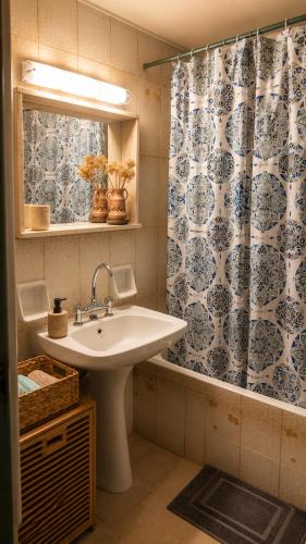a bathroom with a sink and a shower curtain at The Blue - Kythira in Kondoliánika