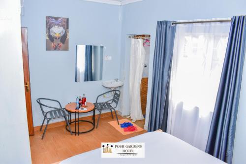 a room with two chairs and a table and a bed at Posh lounge gardens in Gatimu