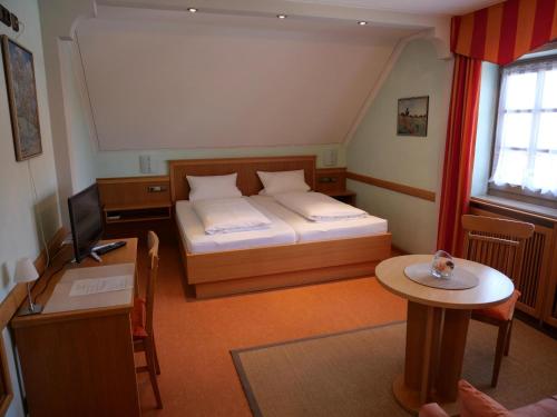 a small room with a bed and a table at Bocksbeutelherberge in Sommerach