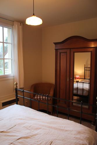 a bedroom with a bed and a dresser and a mirror at Petit Crecy 