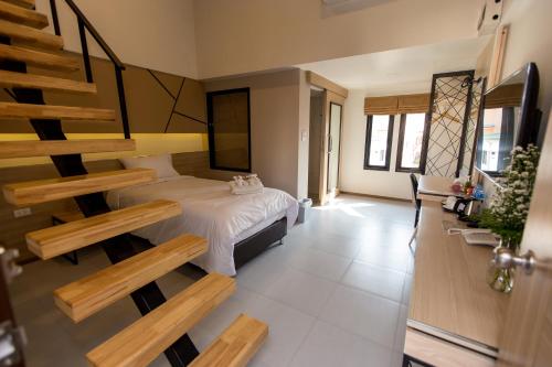 a bedroom with a bed and a spiral staircase at TUCK Me iN in Chiang Mai