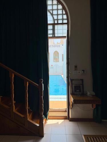 an open door to a swimming pool through a room at Kuwait Palace Hotel in Kuwait