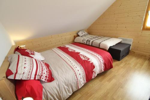 two beds in a small room with at Chalet avec mezzanine 4 étoiles, Saint Mamet, jusqu'à 10 couchages, proche du lac de Gérardmer des commerces et des pistes de ski dans un quartier calme in Gérardmer