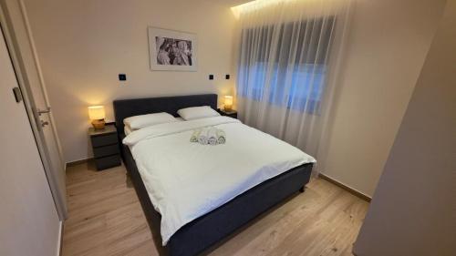 a bedroom with a large bed with white sheets at Villa Jelena Rooms and Apartments in Kovačić