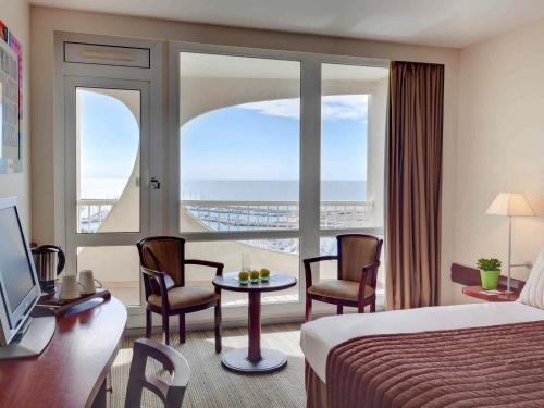 a hotel room with a bed and a view of the ocean at Mercure Port La Grande Motte in La Grande Motte