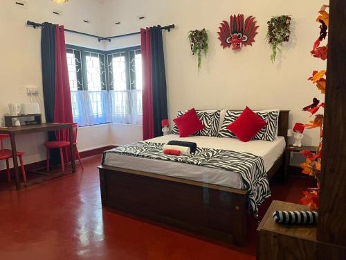 a room with a bed with red pillows on it at LUMBINI B&b in Kandy