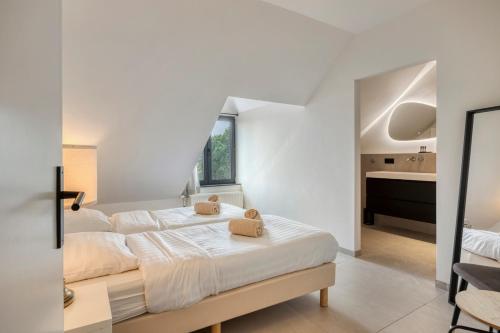 a white bedroom with a bed and a sink at Hoeve de Eik in Epen
