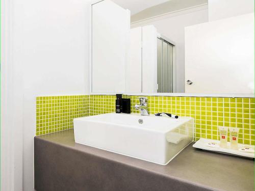 a bathroom with a white sink and a mirror at ibis Styles Geraldton in Geraldton