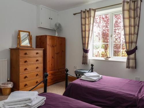 a bedroom with a bed and a dresser and a window at Lillieput Lodge in Melbourne